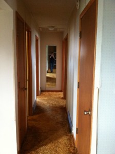 a hallway of doors with a mirror